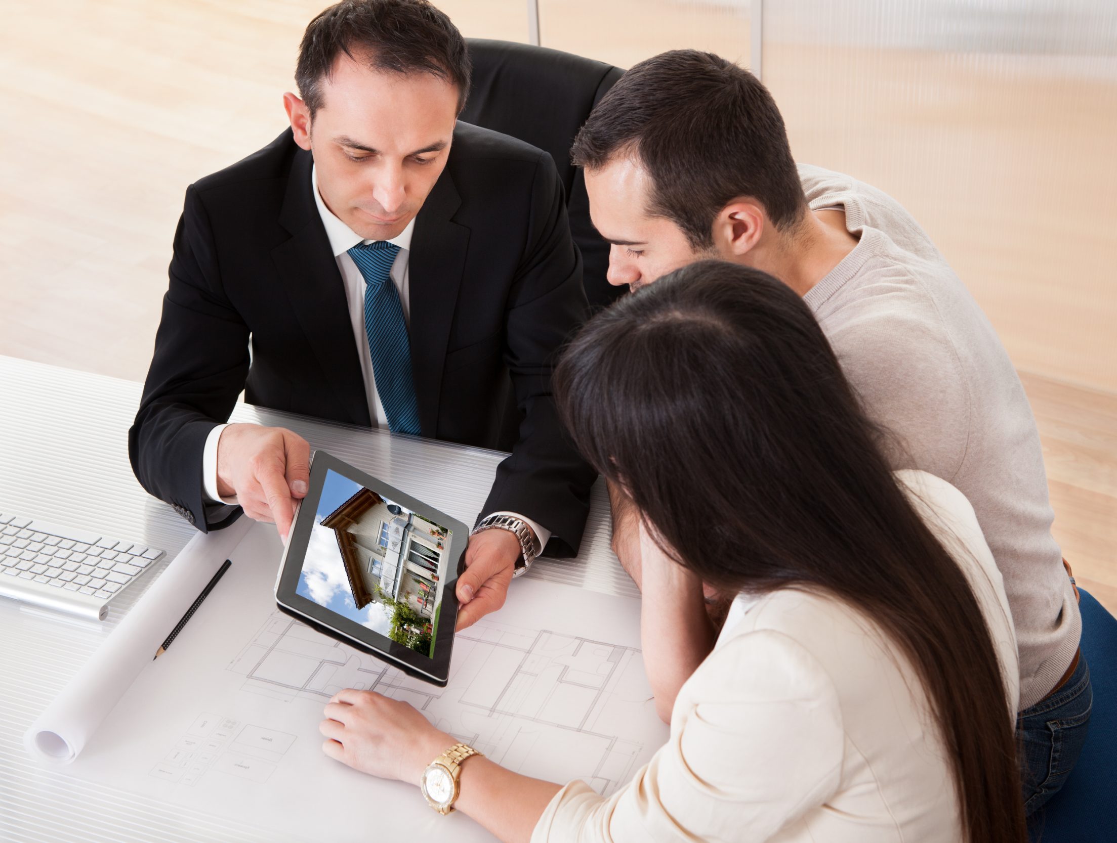 A realtor showing a home to homebuyers on a tablet A realtor showing a home to homebuyers on a tablet